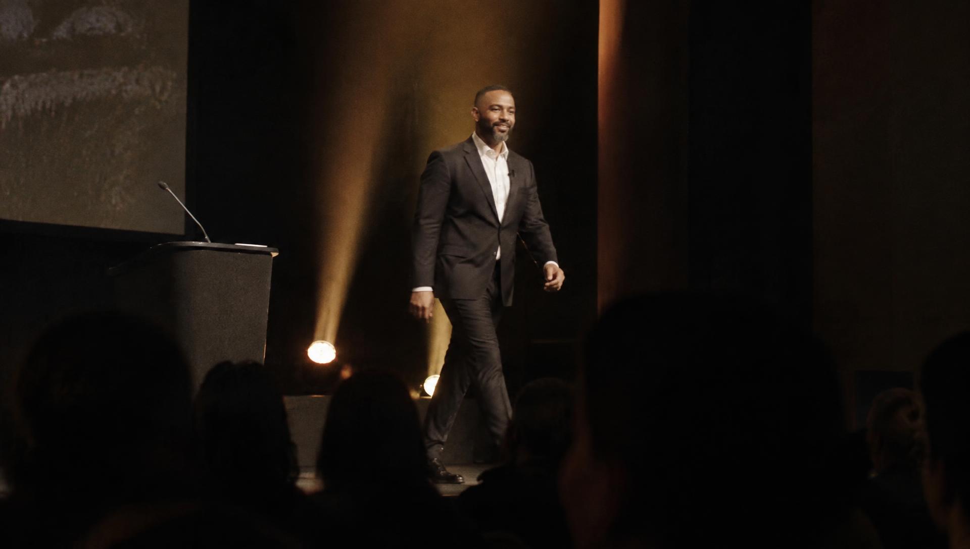 Speaker walking onstage at a conference